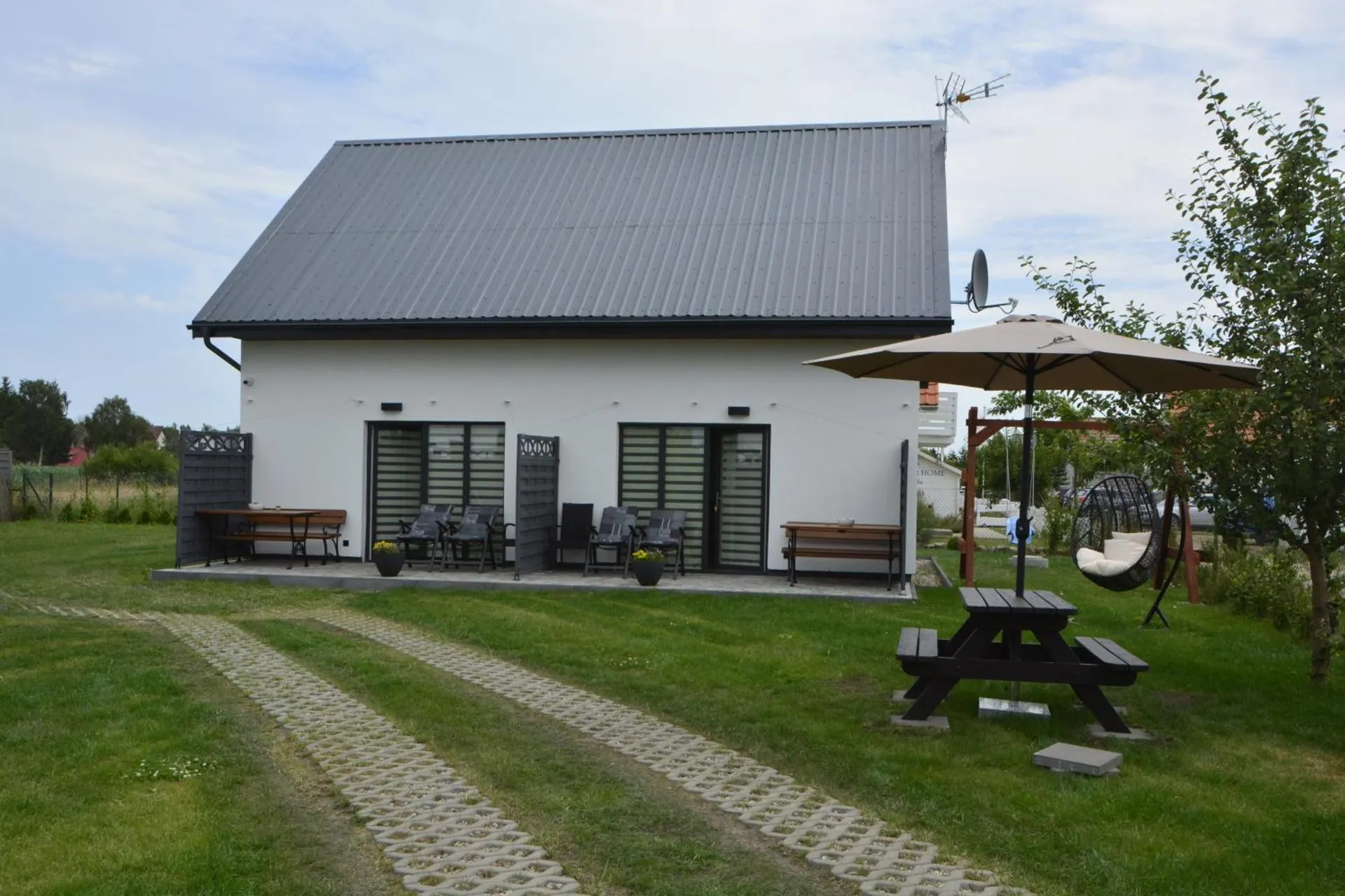 Domek z tarasami, dużym parasolem ogrodowym i fotelem-kokonem