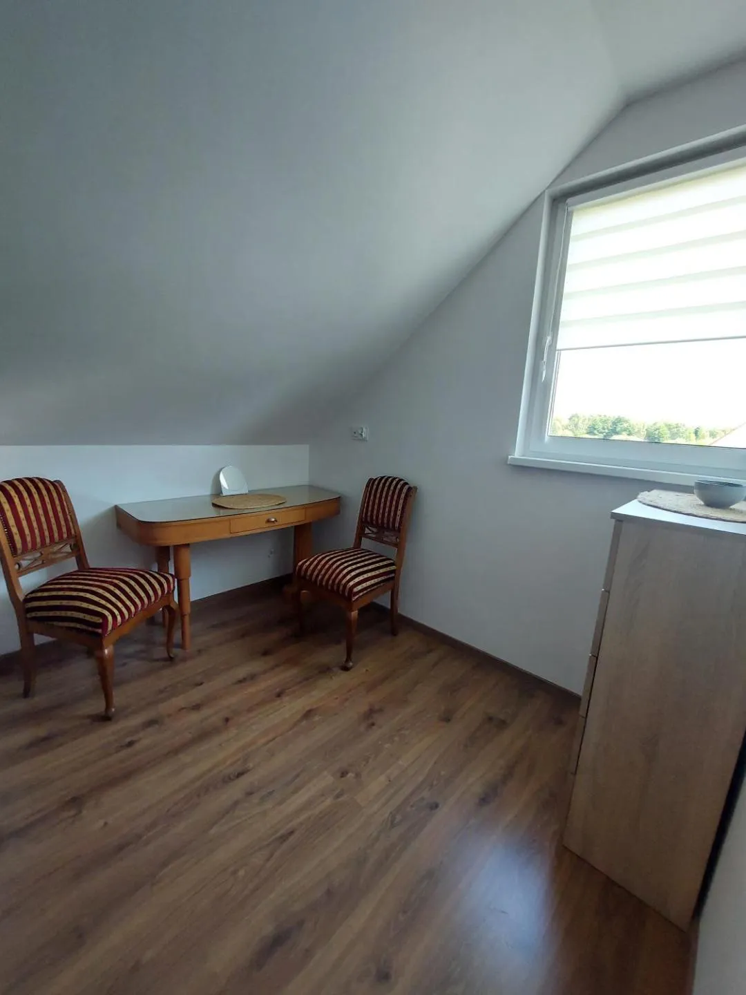 Kącik na poddaszu z toaletką, lusterkiem i krzesłami w pasy